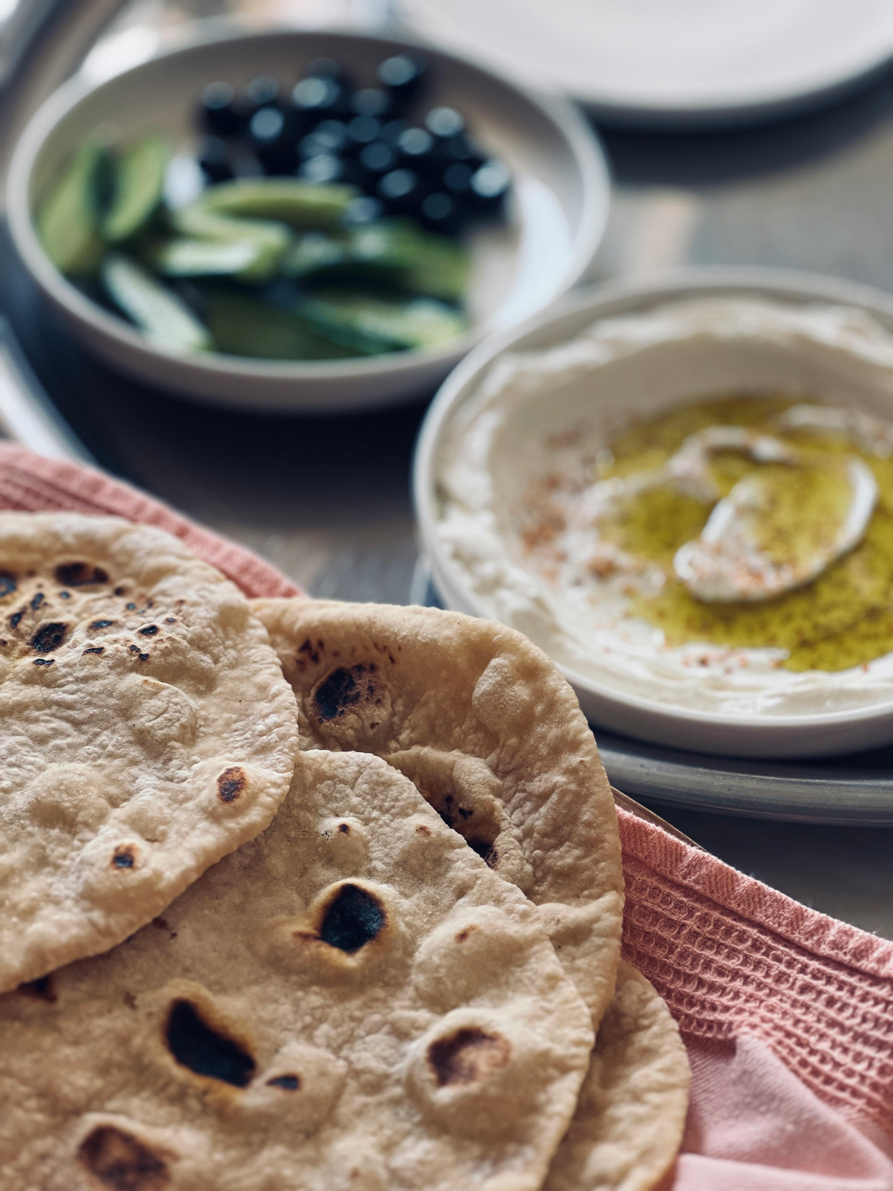 Pan griego tradicional como referencia visual del origen mediterráneo de PizzAtenas